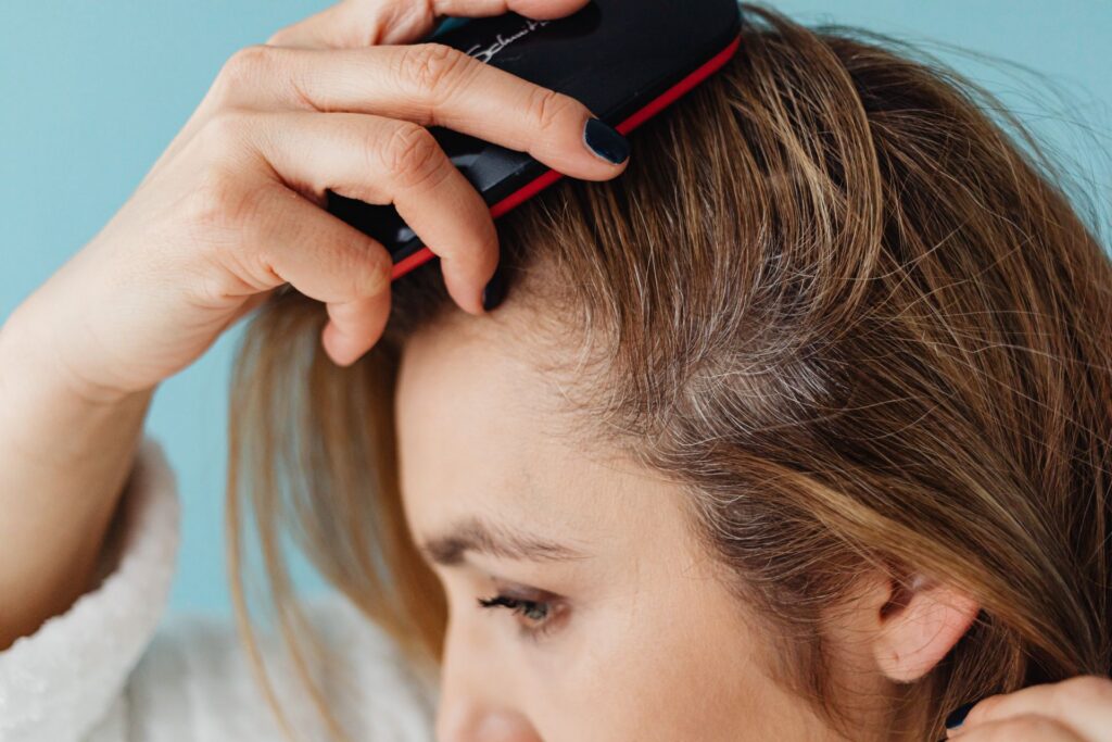 Femme brossant ses cheveux à partir des racines
