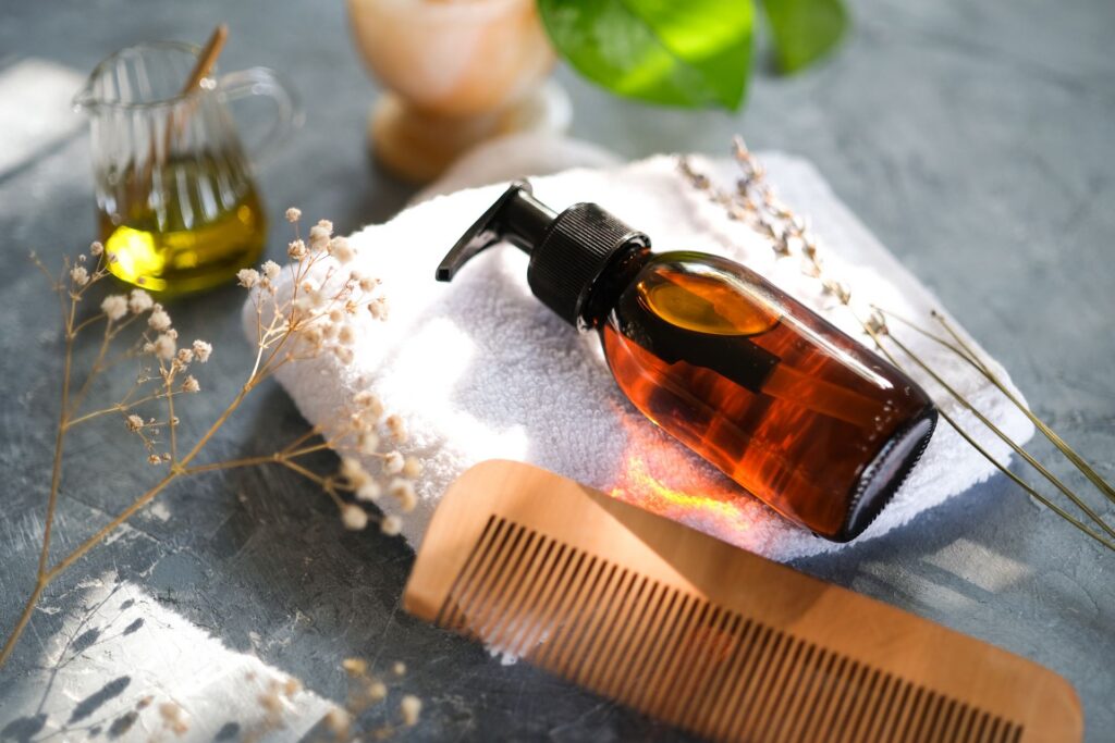 Flacon d'huile, peigne en bois et serviette pour un massage crânien à l'huile