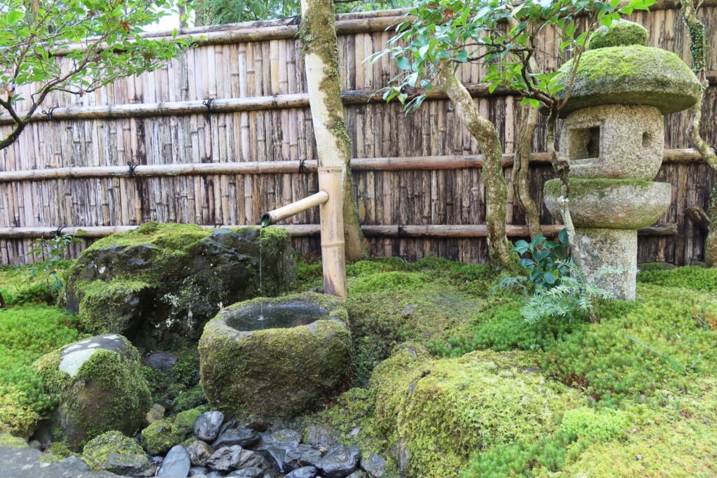 Jardin japonais avec lanterne de pierre, bambous et mousse à Kyoto