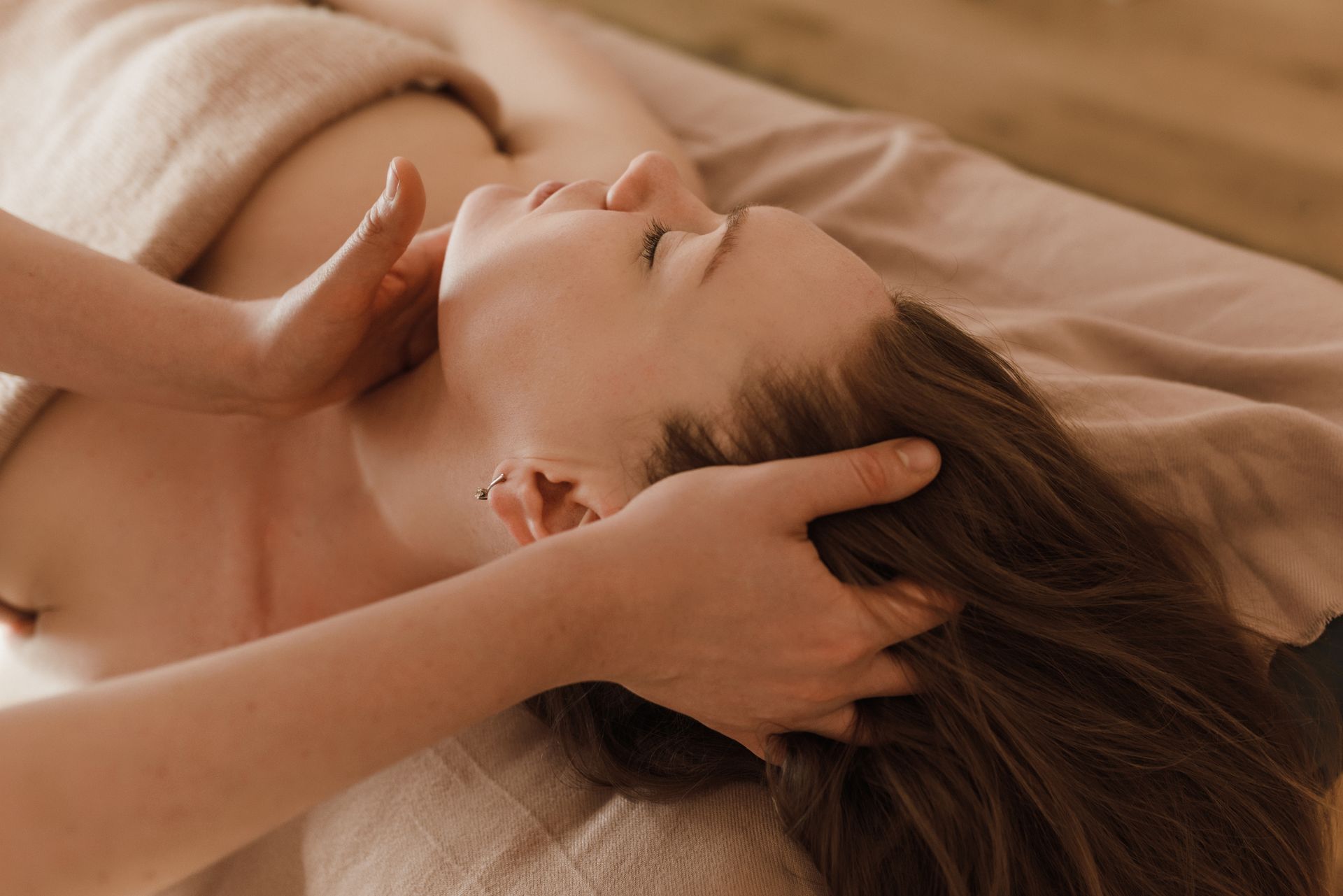 Mains massant le cuir chevelu et la nuque d'une femme allongée