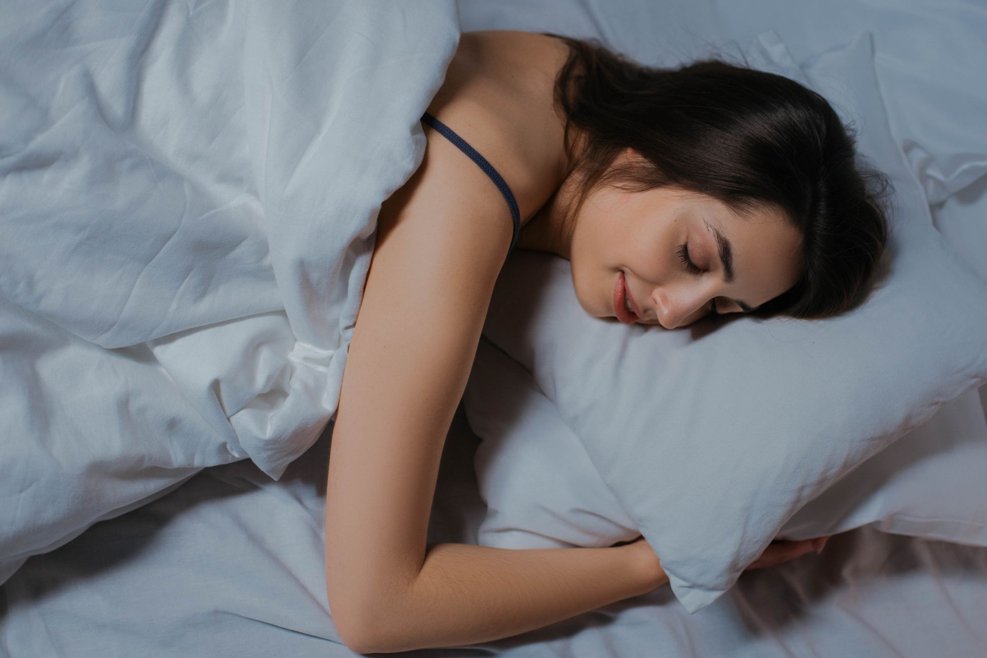 Femme endormie paisiblement sur un oreiller blanc